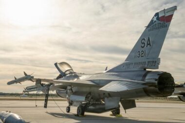 F 16 fighter jet parked on an airstrip with an open cockpit and US Air Force markings on the tail tail code SA 321