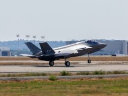 F 22 Raptor stealth fighter on a runway with landing gear down preparing for takeoff at an airbase
