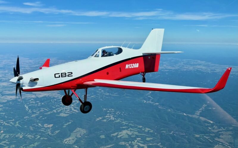Recently Saved 1 of 1 17 Small red and white single engine aircraft in flight over countryside propeller blurred from speed cockpit visible with pilot inside