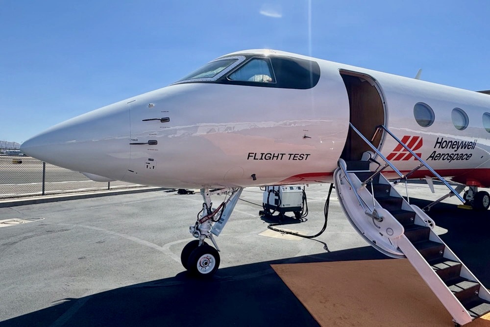 Recently Saved 1 of 1 2 Front three quarter view of a white test aircraft with the door open and stairs deployed on a tarmac labeled Flight Test and branded Honeywell Aerospace