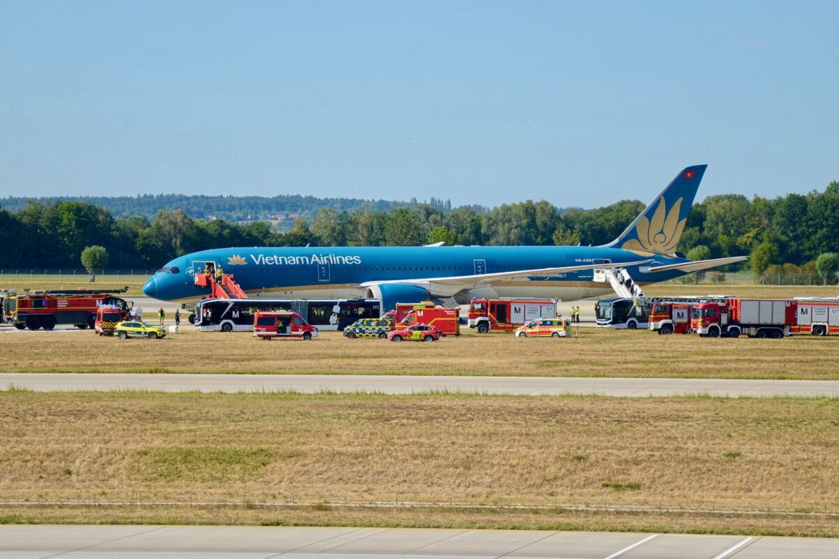 Recently Saved 1 of 1 23 Vietnam Airlines plane on the tarmac surrounded by multiple red emergency vehicles and ground crew at an airport