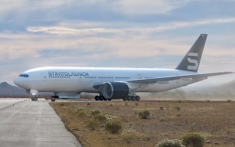 Recently Saved 1 of 1 25 Large white commercial airliner on a taxiway in a desert airfield with a dark tail fin bearing a light logo and distant mountains in the background