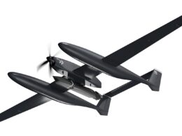 Twin fuselage unmanned aerial vehicle drone with a long wing and vertical tail shown in flight against a white background from a top right perspective