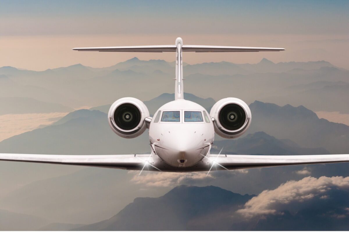 Recently Saved 1 of 1 6 Front on view of a white passenger jet approaching the camera with mountains and clouds in the background during flight