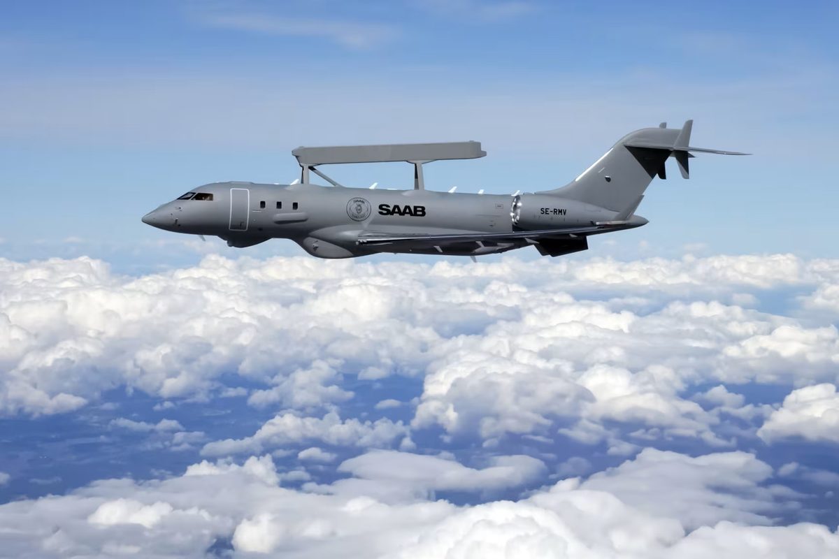 Saab GlobalEye airborne early warning and control AEWC aircraft Gray Saab aircraft in midflight above a sea of white clouds side view with insignia visible on fuselage
