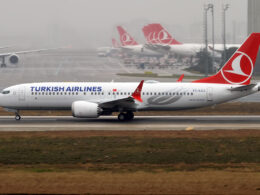 Turkish Airlines Boeing 737 Max taxiing on the runway fuselage marked TURKISH AIRLINES with a red tail logo in the background