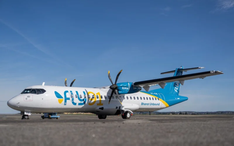Commercial turboprop aircraft with blue and white livery parked on an airport apron against a clear blue sky