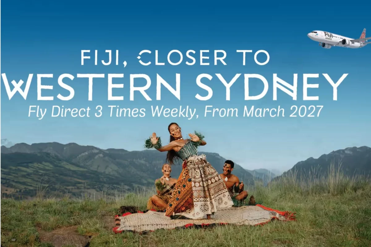Promotional Fiji banner showing dancers in traditional dress in a field with bold white text FIJI CLOSER TO WESTERN SYDNEY and Fly Direct 3 Times Weekly From March 2027 and a plane in the sky