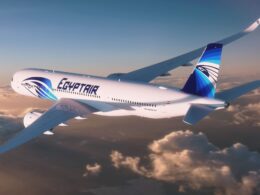 EgyptAir passenger jet in flight above the clouds displaying blue tailed livery and logo on the fuselage