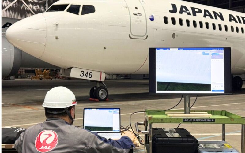 JAL and Donecle launch autonomous drone aircraft inspection Inside a hangar a Japan Airlines jet is parked with technicians at laptops in front of a large monitor displaying system data