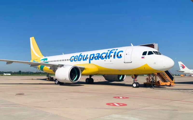 Cebu Pacific takes delivery of third A320neo for 2026 Cebu Pacific passenger jet on the tarmac beside a jet bridge under a clear blue sky