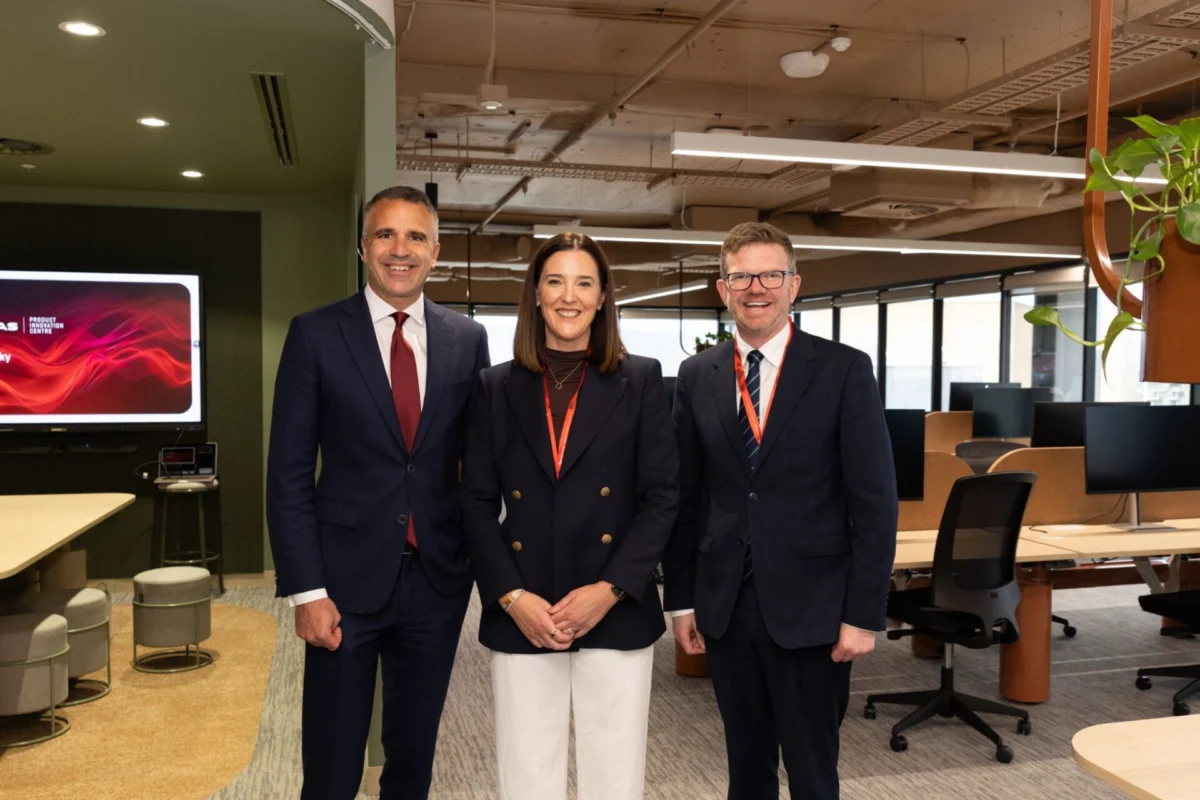 Qantas opens Product Innovation Center in Adelaide Three professionally dressed colleagues pose for a group photo in a modern office lobby