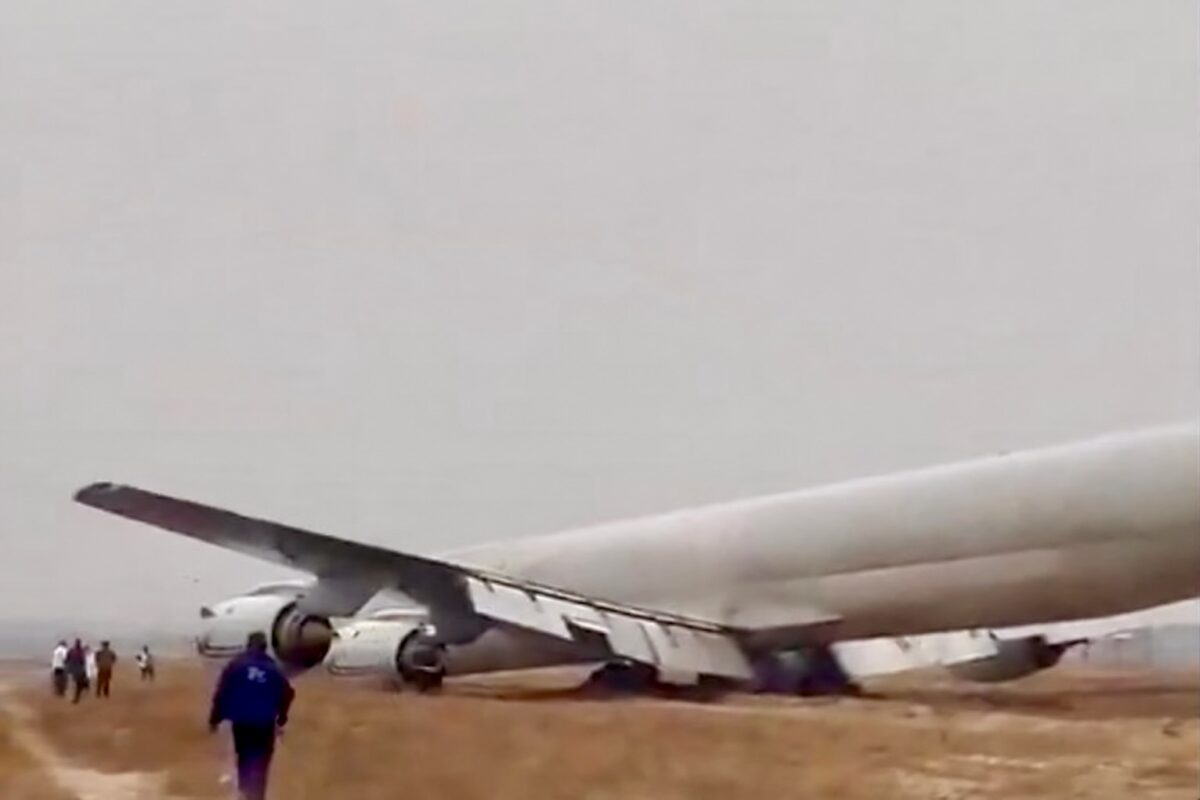 dc8congo A large passenger jet lies wrecked on a dirt airfield wings damaged and fuselage crumpled while several people stand nearby observing