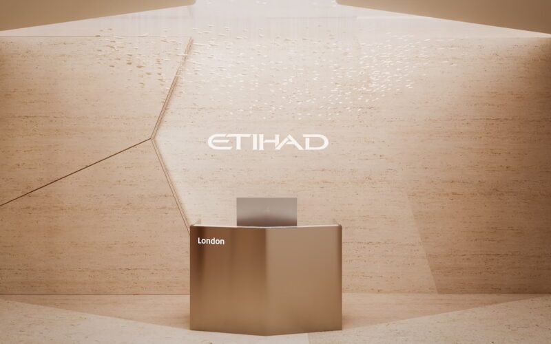 etihad to elevate premium ground experience with new generation of global lounges Bronze reception desk against a light tan wall with the Etihad logo and the word London nearby
