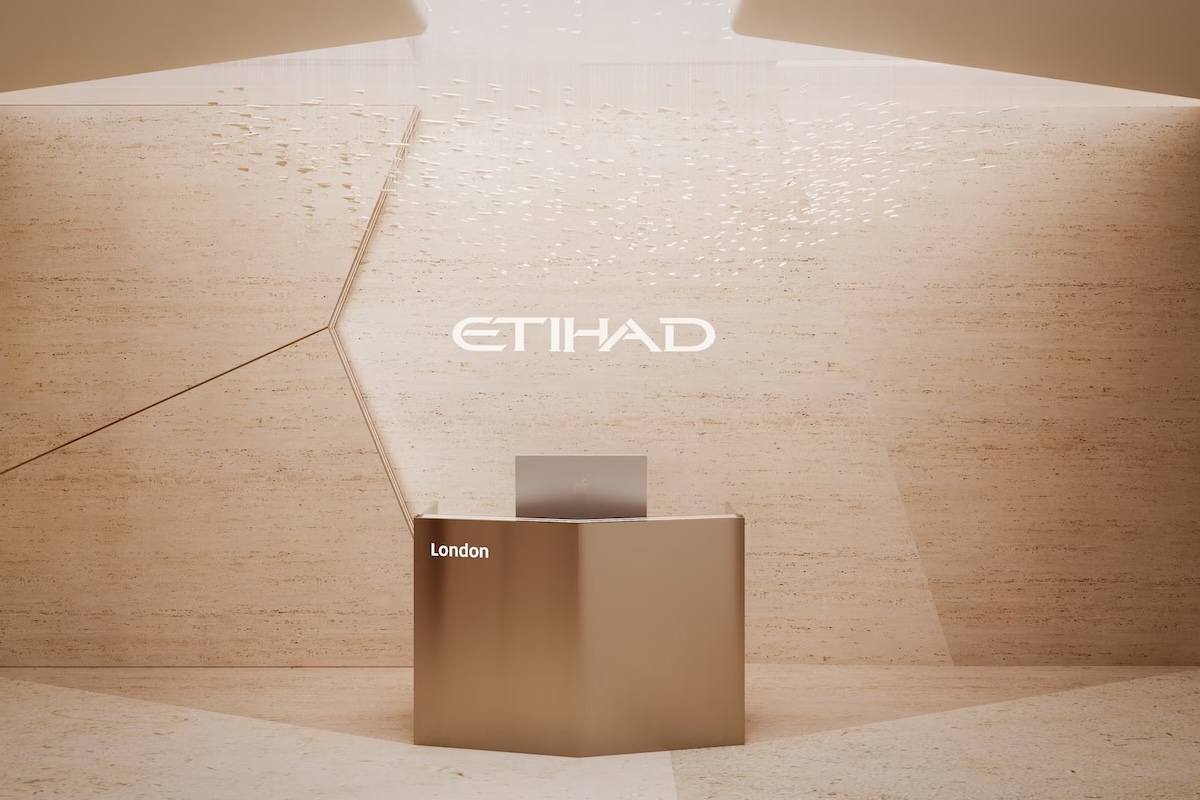etihad to elevate premium ground experience with new generation of global lounges Bronze reception desk against a light tan wall with the Etihad logo and the word London nearby