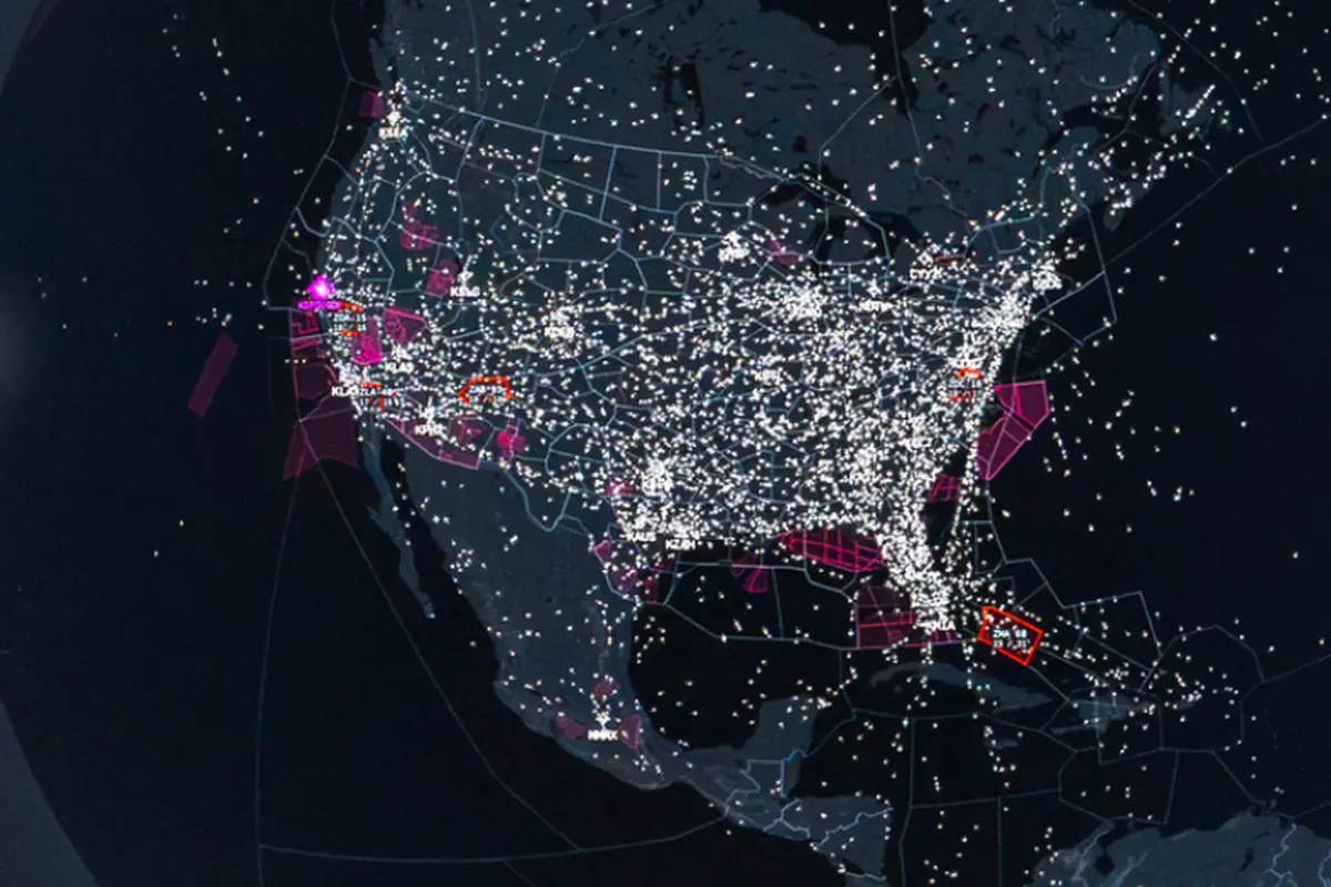 Nighttime map visualization showing dense air traffic with white dots and flight paths across a region magenta hubs and red outlined areas highlight key airports or zones