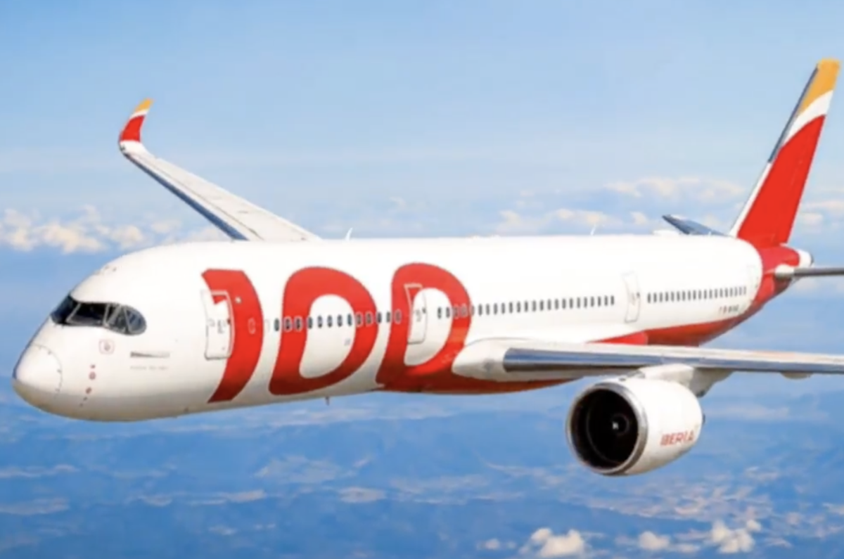 iberia 100 livery White commercial jet in flight above clouds with large red branding 100 along the fuselage and red tail fin