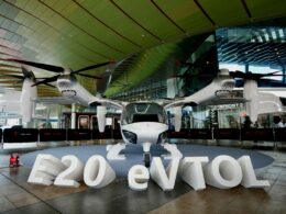 White four rotor eVTOL aircraft on display at an indoor exhibition with large E20 eVTOL letters in front