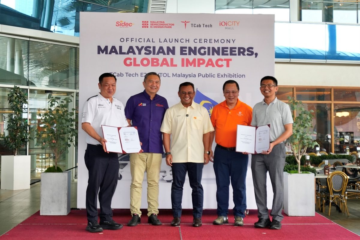 02 SIDEC TCab MOU Ceremony Five men pose with open documents on a red carpet at an official launch event titled Malaysian Engineers Global Impact with a large banner in the background