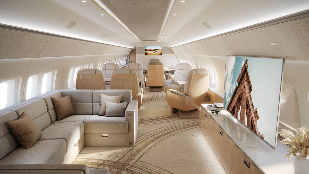 BBJ Select 737 7 FWD lounge A serene Luxurious private jet cabin with beige leather seats a cream sofa ambient lighting and a wall mounted TV showing a stone arch