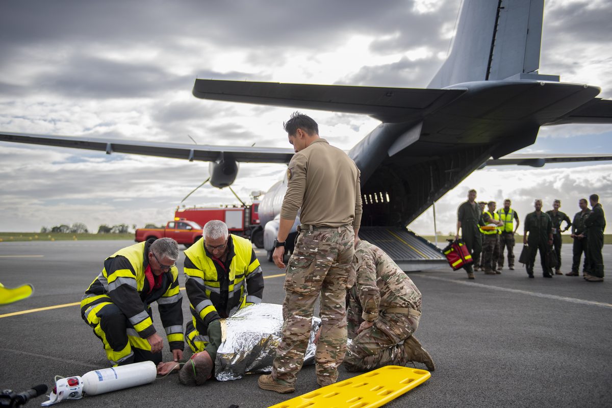 2026 ACTAAE 056 LFRA ACE Dinard Emergency responders and soldiers load or treat a patient on the tarmac beside a large military transport aircraft with its rear ramp open scene of a medical drill