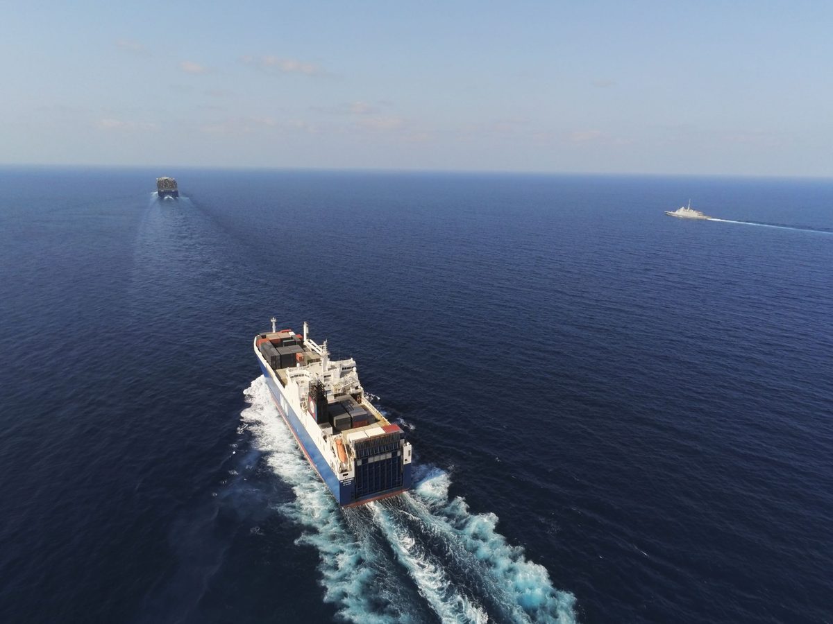 French Navy FREMM frigate Languedoc escorts a convoy through the Red Sea in an image released on October 9 2026 Aerial view of a large container ship sailing through open ocean with a smaller vessel visible in the distance on the horizon leaving a wake behind it