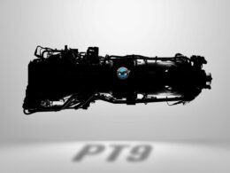 Silhouette of a large aircraft jet engine with a blue circular emblem on its side against a light gray background