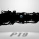 Silhouette of a large aircraft jet engine with a blue circular emblem on its side against a light gray background