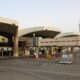 Airport terminal with curved jet bridges and glass facade ground equipment and vehicles on the tarmac