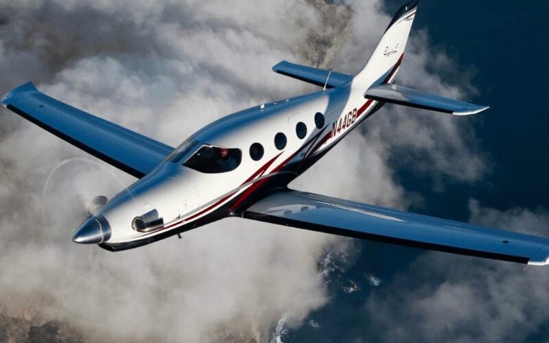 Recently Saved 1 of 1 28 White and blue private jet with red stripe flying above clouds viewed from the front left