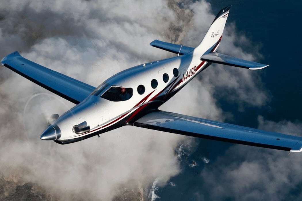 Recently Saved 1 of 1 28 White and blue private jet with red stripe flying above clouds viewed from the front left