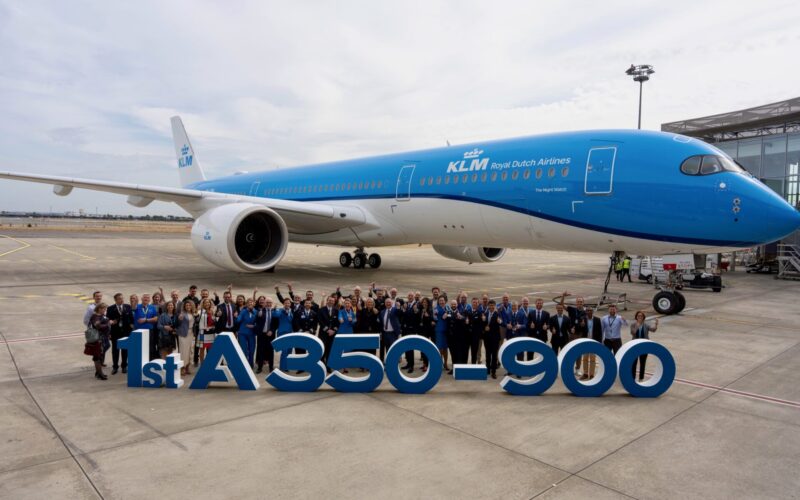 Recently Saved 1 of 1 30 Group of people posing in front of a blue KLM Airbus A350 900 on the tarmac celebrating the first delivery with a large display reading 1st A350 900 in the foreground