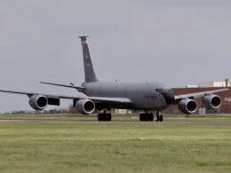 US Air Force C 17 cargo aircraft taxiing on a runway four engines visible gray fuselage hangar backdrop