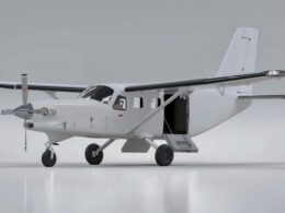 White high wing single engine utility airplane with an open side door and fold out stairs on a glossy hangar floor area