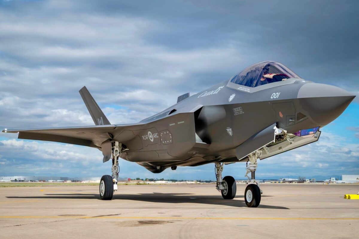 Recently Saved 1 of 1 8 Side view of a gray stealth fighter jet on a tarmac cockpit canopy closed landing gear down in bright daylight under a cloudy sky