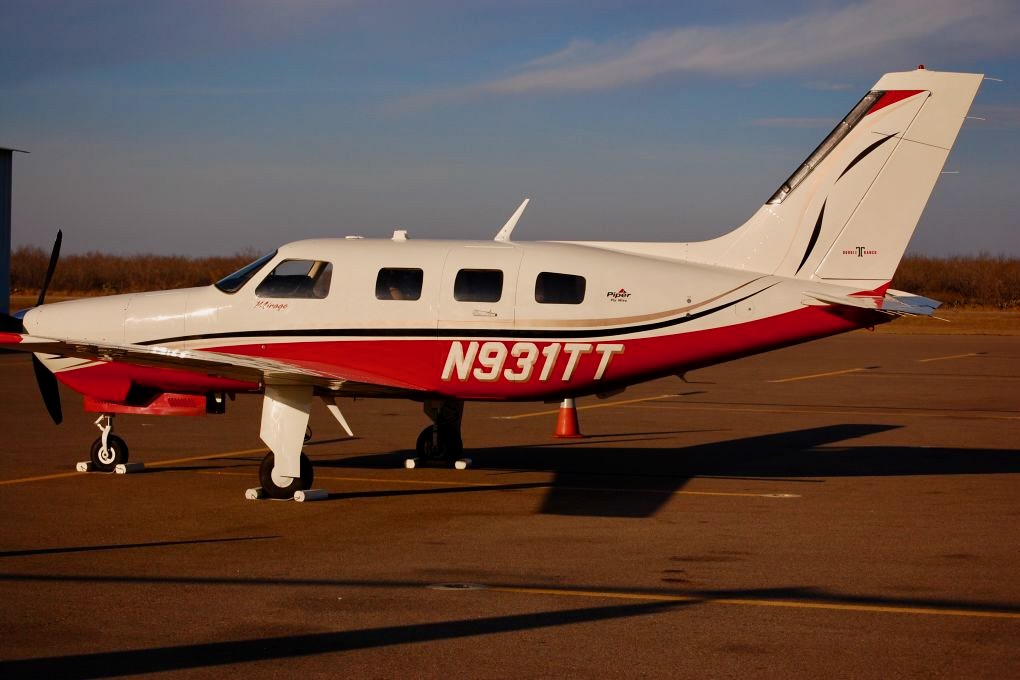 Recently Saved 1 of 1 8 Side view of a white and red Piper private airplane with tail number N931TT parked on an airport tarmac gear down sunny day
