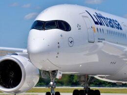 Close up of a white Lufthansa Airbus A350 900 nose with cockpit windows and left engine on a runway