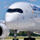 Close up of a white Lufthansa Airbus A350 900 nose with cockpit windows and left engine on a runway