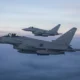 Two Royal Air Force Typhoon fighter jets fly in formation during a NATO training exercise