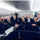 Group of flight attendants in uniform posing together inside an airplane cabin for a crew photo