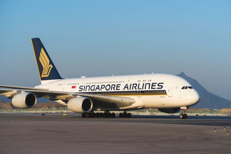 Singapore Airlines Airbus A380 on the taxiway tail fin with the gold logo four engines visible against a clear blue sky