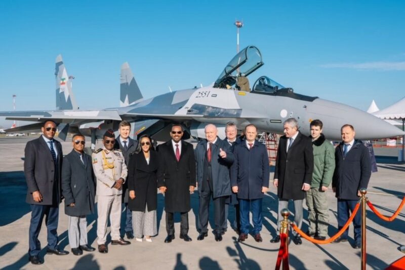 Ethiopia gets Russian Su 35 jets a year ahead of schedule Group of officials and military personnel posing in front of a gray fighter jet with an open cockpit on a sunny airfield