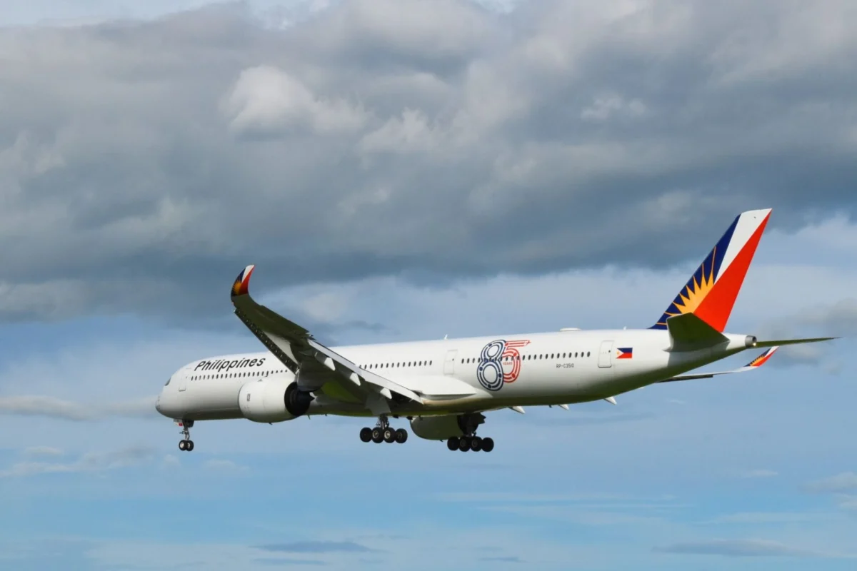 Narrow body airliner in the sky with landing gear down Philippine Airlines livery and a red blue and orange tail fin visible