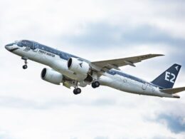 Commercial airplane in flight with Profit Hunter livery engines under wings landing gear extended tail marked E2