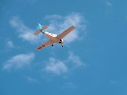 Small single engine airplane in midflight against a clear blue sky registration EC UBV visible on the fuselagewing