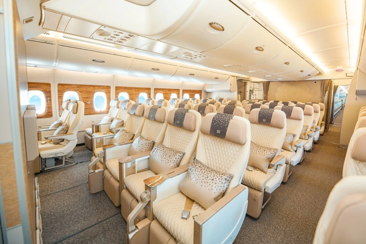 Emirates swaps Boeing 777 for A350 on Dubai Mauritius flight Wide view of a premium airplane cabin with beige leather seats wood paneled walls and overhead storage panels