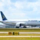 AirAsia passenger jet on the taxiway with a blue tail and yellow logo at an airport