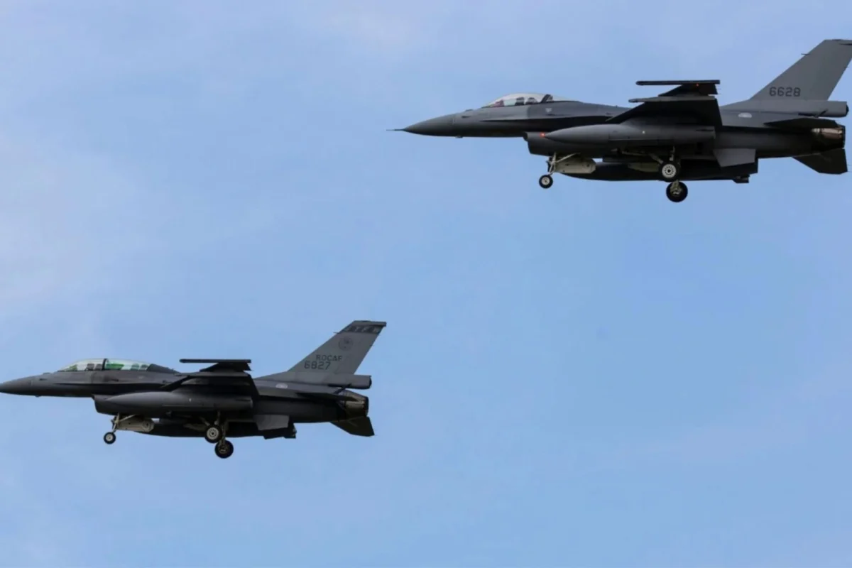 Taiwan gets first F 16V Block 70 jets amid Beijing pressure Two gray military fighter jets in formation with landing gear down against a blue sky tail numbers 6827 and 6628 visible