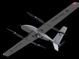 Gray fixed wing drone with four propellers and BEYOND VISION on the wings against a black background