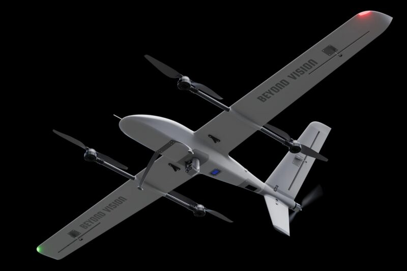 beyond vision drone Gray fixed wing drone with four propellers and BEYOND VISION on the wings against a black background